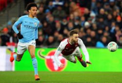 Callum Chambers of Arsenal heads back to the goalkeeper under pressure from Leroy Sane of Manchester City