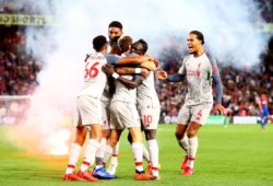 Sadio Mane of Liverpool celebrates scoring a goal to make the score 0-2 with team mates as a flare is thrown on the pitch