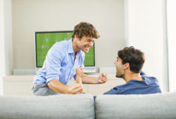 Men cheering and watching soccer game