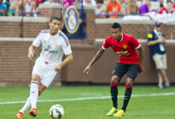 Real Madrid forward Cristiano Ronaldo, left, dribbles the ball, defended by Manchester United midfielder Jesse Lingard, right, in the second half of a Guinness International Champions Cup soccer match at Michigan Stadium, Saturday, Aug. 2, 2014, in Ann Arbor, Mich. Manchester United won 3-1. (AP Photo/Tony Ding)