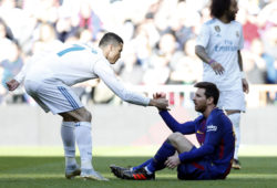 Real Madrid's Cristiano Ronaldo, left, helps Barcelona's Lionel Messi get back on his feet during the Spanish La Liga soccer match between Real Madrid and Barcelona at the Santiago Bernabeu stadium in Madrid, Spain, Saturday, Dec. 23, 2017. (AP Photo/Francisco Seco)