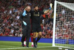 Liverpool's goalkeeper Alisson Becker, right, waves to the fans as he leaves the pitch after an injury during the English Premier League soccer match between Liverpool and Norwich City at Anfield in Liverpool, England, Friday, Aug. 9, 2019. (AP Photo/Dave Thompson)