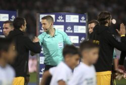 In this Sunday, Sept. 23, 2018, photo Finnish international referee Mattias Gestranius, center, shakes hands with the players before a Greek Soccer League match between PAOK and AEK Athens at Toumba stadium in the northern Greek city of Thessaloniki.  Gestranius and his fellow Finnish linesmen were the first foreigners to be in charge of a Greek league game in 43 years, at Thessaloniki?Äôs Toumba Stadium.  (AP Photo/Giannis Papanikos)
