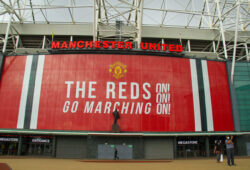 A couple wearing face masks as a preventive measure take photos outside the Old Trafford stadium in Manchester. The Government has made it mandatory to wear face coverings in all public transport, supermarkets and indoor shopping centers as a measure to combat the spread of the novel coronavirus. (Photo by David Mbiyu / SOPA Images/Sipa USA)