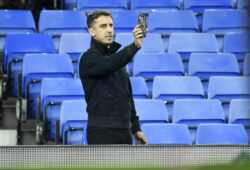 Gary Neville, former Manchester United soccer player and part-owner of Salford City on his smart phone before the English League Cup soccer match between Everton and Salford City at Goodison Park in Liverpool, England Wednesday, Sept. 16, 2020. (Peter Powell/Pool via AP)  TH123